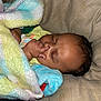 Deja is registered to the contest to win money with this photo: baby, sleeping, blanket, colorful, hand, thumb, face, infant, cozy, resting, soft, cushion, comfort, closeup, child, indoors, cute, peaceful, portrait, young