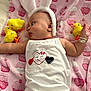 baby, bunny_ears, blanket, yellow_chick, toy, onesie, bracelet, pink, cute, infant, lying_down, face, earrings, pattern, soft_toy, child, smiling_heart, decor, playful, cozy