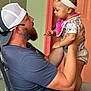 Amariah is registered to the contest to win money with this photo: man, baby, child, holding, portrait, outdoor, cap, beard, headband, floral_clothing, pink_bib, arm, chair, interaction, love, family, casual, smile, skin, person