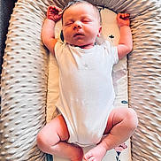 Perrin is registered to the contest to win money with this photo: baby, newborn, sleeping, infant, cushion, white_clothing, arms_up, peaceful, soft_texture, floral_pattern, indoors, skin, legs, feet, head, face, peace, comfort, blanket, rest