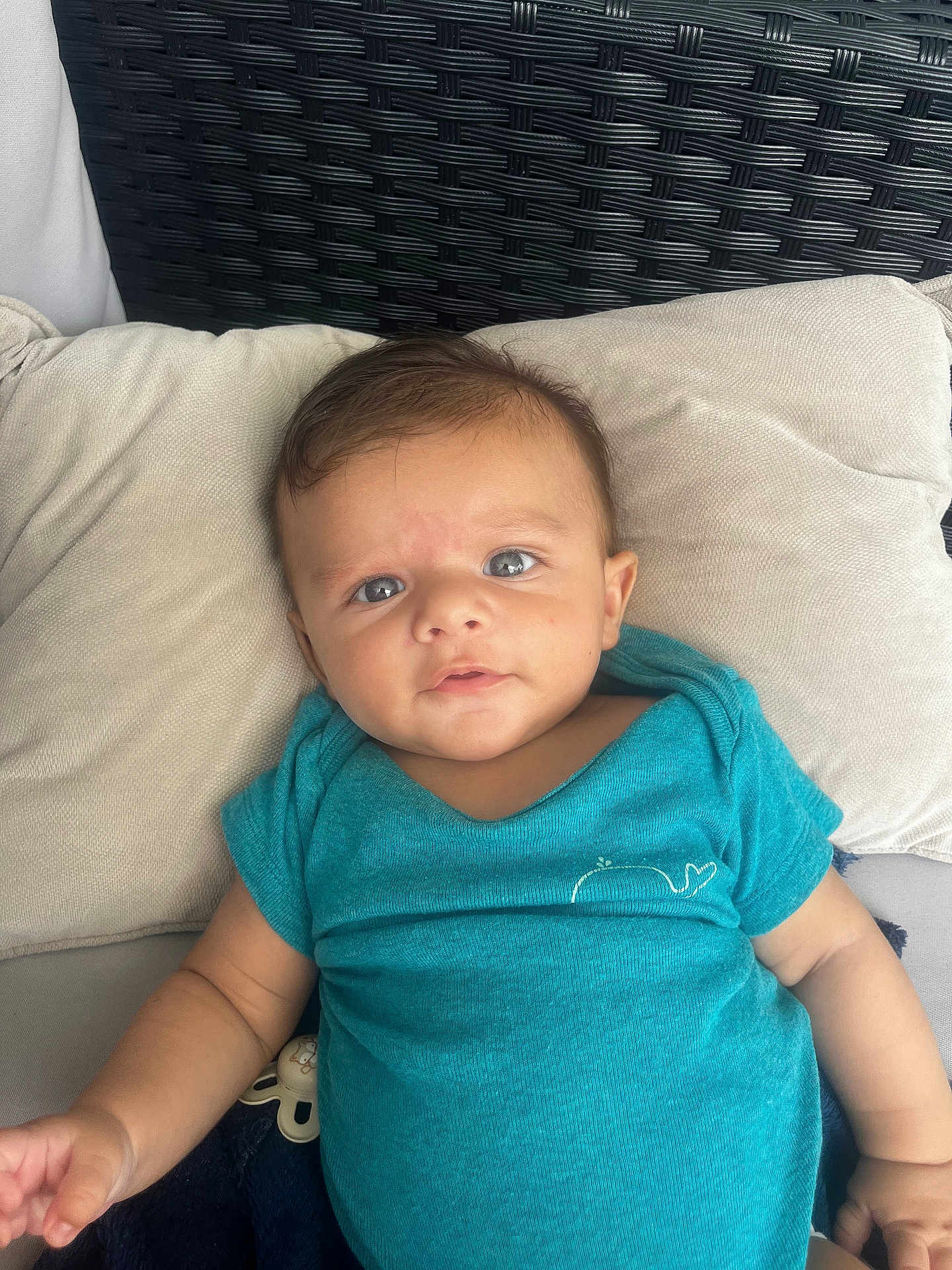 Ayan participe au concours pour gagner de l'argent avec cette photo : baby, infant, child, pillow, cushion, blue_shirt, whale_emblem, soft_texture, woven_background, indoor, portrait, cute, relaxed, cozy, small_hand, head, face, eyes, skin, clothing