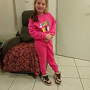 Jade participe au concours pour gagner de l'argent avec cette photo : armchair, blanket, casual_clothing, child, door, floor_tiles, girl, happy, home, indoor, long_hair, person, pink_outfit, posing, smile, sneakers, standing, sweatshirt, wall, young