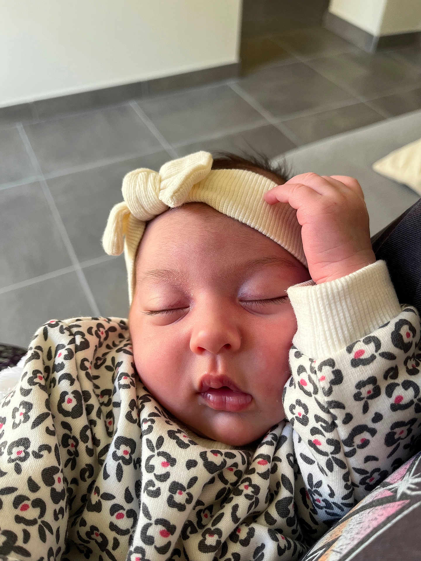 Ava participe au concours pour gagner de l'argent avec cette photo : baby, sleeping, headband, infant, clothing, patterned_clothing, leopard_print, hand, face, closed_eyes, indoors, floor_tiles, couch, comfort, cute, peaceful, portrait, child, soft_lighting, cozy
