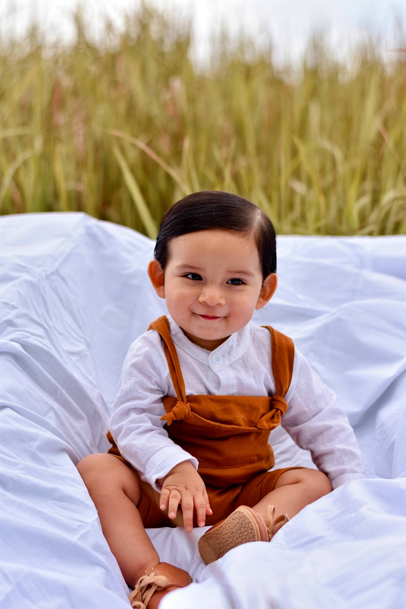 Thiago is registered to the contest to win money with this photo: baby, baby_toddler_clothing, black_hair, child, dress, event, flash_photography, formal_wear, fun, gesture, grass, happy, human_body, joy, leisure, people_in_nature, person, sitting, skin, sleeve