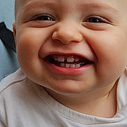 Ardyan a rejoint le concours — aidez-le/la à gagner de superbes lots ! baby, smiling, close_up, face, teeth, child, infant, joyful, white_shirt, red_text, chubby_cheeks, happy, cute, portrait, skin, head, eyes, mouth, expression, person