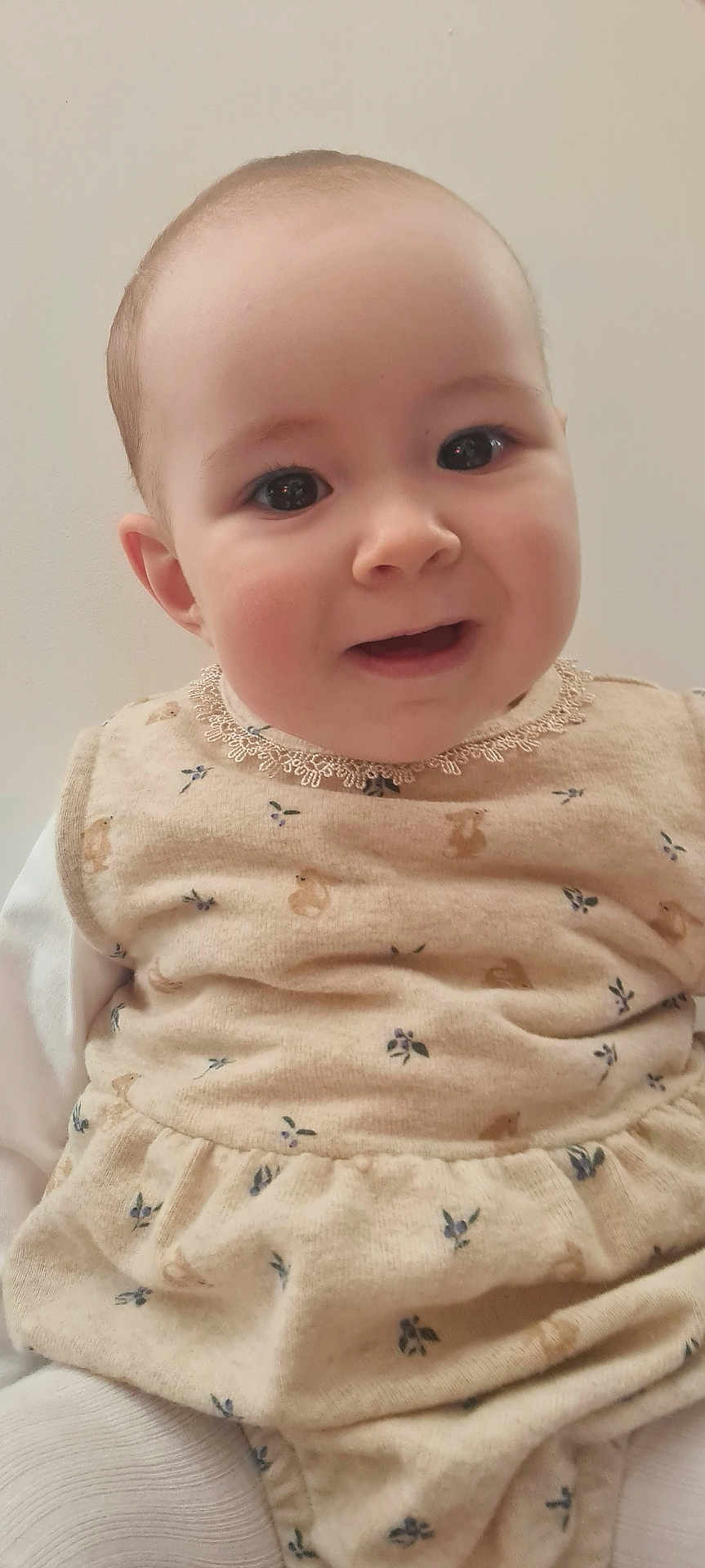 Emy a rejoint le concours — aidez-le/la à gagner de superbes lots ! baby, child, face, smile, eyes, clothing, beige, pattern, infant, cute, portrait, person, young, sitting, indoor, head, expression, soft, warm, comfortable