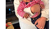 Aaron is registered to the contest to win money with this photo: adult, baby, casual, child, clothing, floor, hand, happy, holding, indoor, navy_pants, person, red_checkered_shirt, shopping_bag, smiling, sunglasses, television, tongue_out, toy_car, wooden_floor