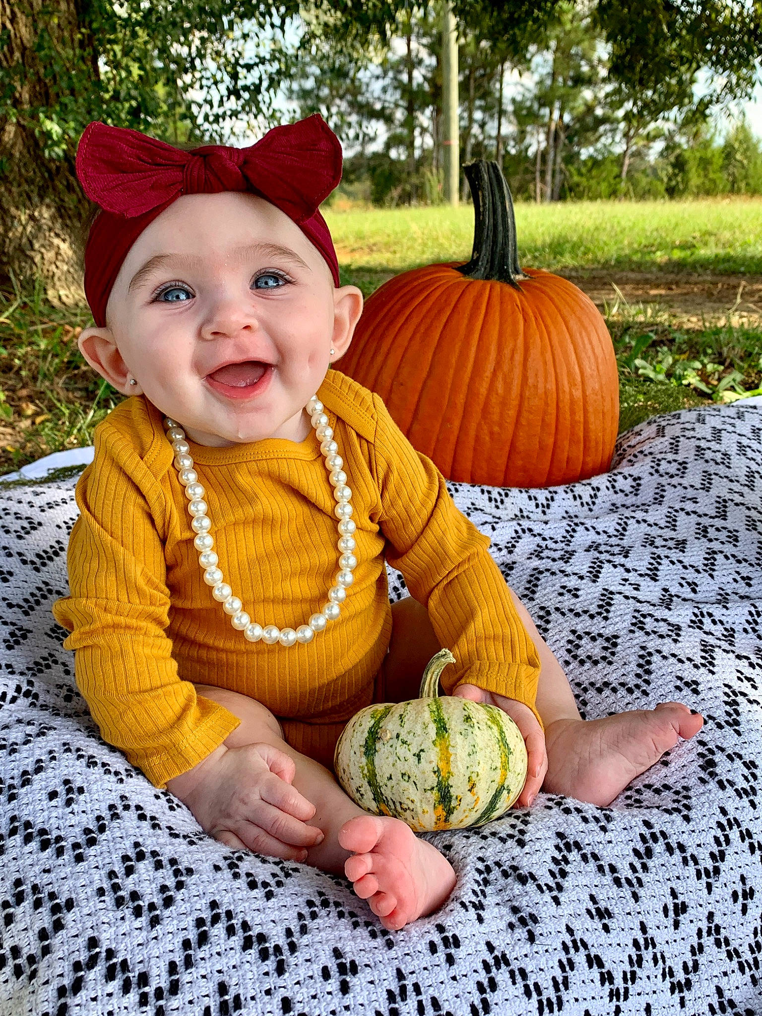 Mia Faye joined the competition — help win amazing prizes! baby_toddler_clothing, calabaza, cucurbita, eye, gourd, grass, happy, head, headwear, human_body, leaf, mammal, orange, people_in_nature, person, photograph, plant, pumpkin, smile, toddler