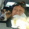 bouquet, car, companion, dashboard, dog, flowers, indoor, passenger, person, pet, portrait, road_trip, seated, selfie, smiling, sunglasses, travel, vehicle, white_flowers, woman
