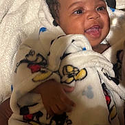 Tiesean joined the competition — help win amazing prizes! baby, smiling, blanket, mickey_mouse, child, happy, cozy, infant, cute, face, portrait, soft, warm, wrapped, hands, lying_down, indoors, toddler, clothing, comfort