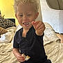 Cyprus joined the competition — help win amazing prizes! child, toddler, curly_hair, snack, crumbs, face, smiling, sitting, bed, blanket, clothing, indoor, furniture, hand, happy, person, cozy, messy, casual, light