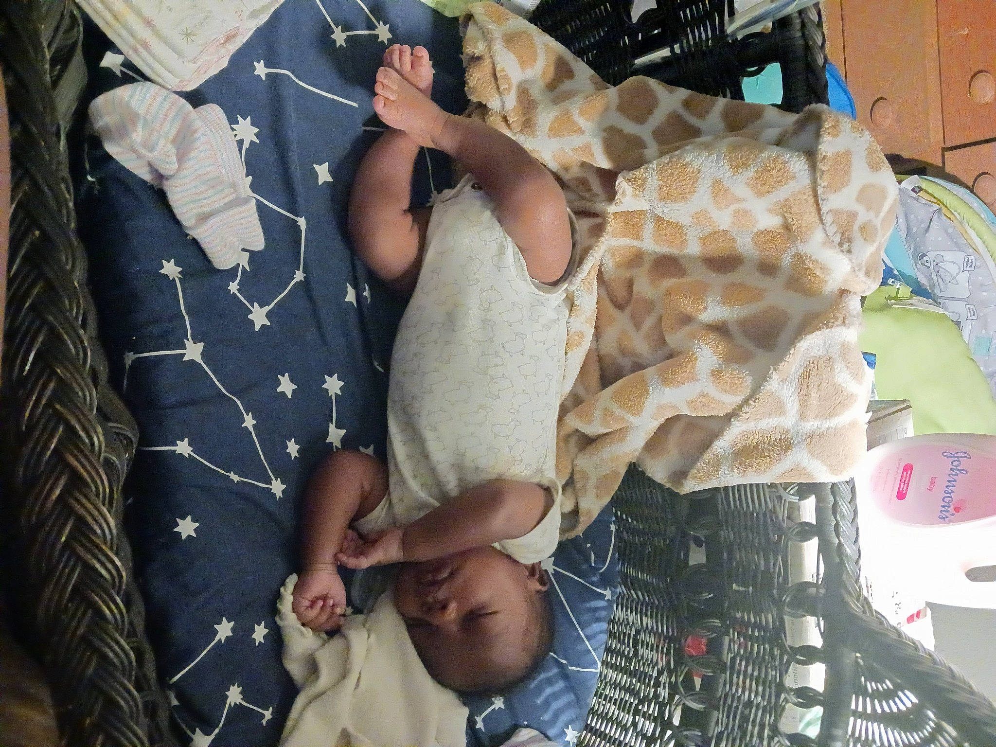 Jeremy is registered to the contest to win money with this photo: baby, baby_products, bedding, child, comfort, eyewear, fashion_accessory, gesture, giraffidae, human_leg, linens, pattern, person, plaid, room, sleeve, sunglasses, t_shirt, textile, toddler