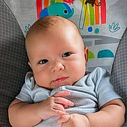 Maxim is registered to the contest to win money with this photo: baby, baby_seat, bird, cartoon, cheeks, child, cute, elephant, expression, face, gray_clothing, hands, indoor, infant, monkey, onesie, pattern, portrait, rainbow, smile