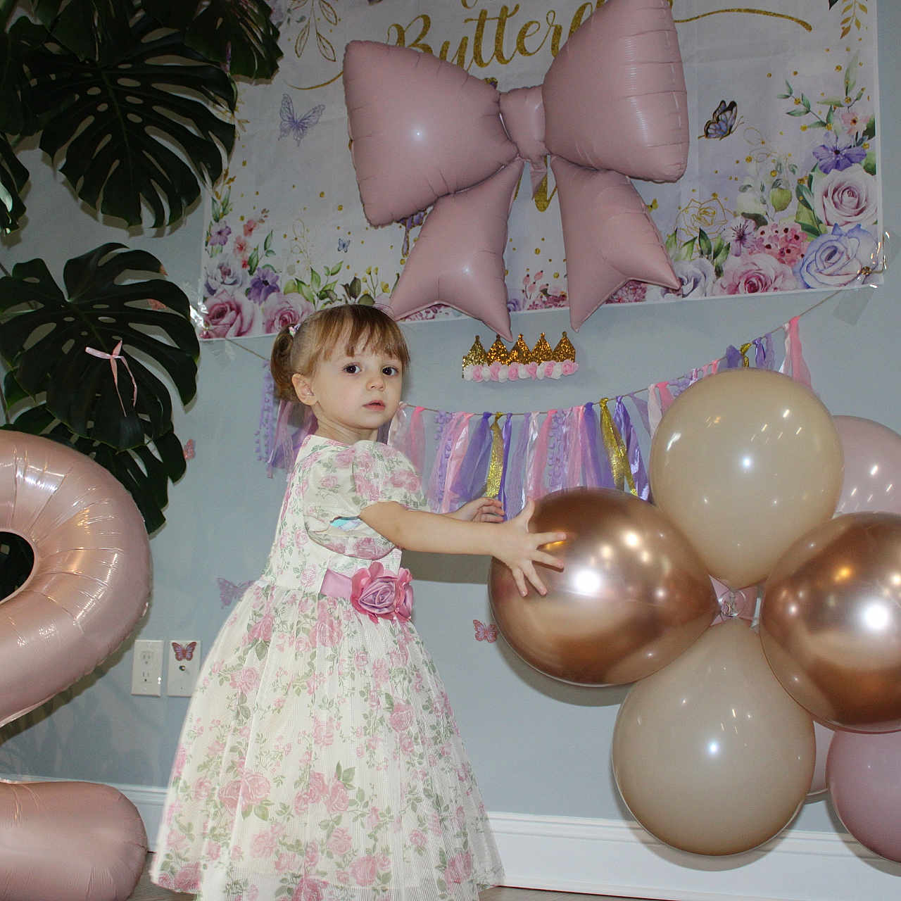 Era joined the competition — help win amazing prizes! balloons, banner, birthday, bow_balloon, celebration, child, crown_decor, dress, floor, floral_dress, girl, indoor, metallic_balloons, monstera, number_balloon, party, party_decor, plant, toddler, wall