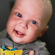 Milan joined the competition — help win amazing prizes! baby, smiling, blue_eyes, close_up, portrait, child, tshirt, sun_graphic, hand, happy, cute, infant, face, skin, expression, cheerful, young, person, clothing, indoors