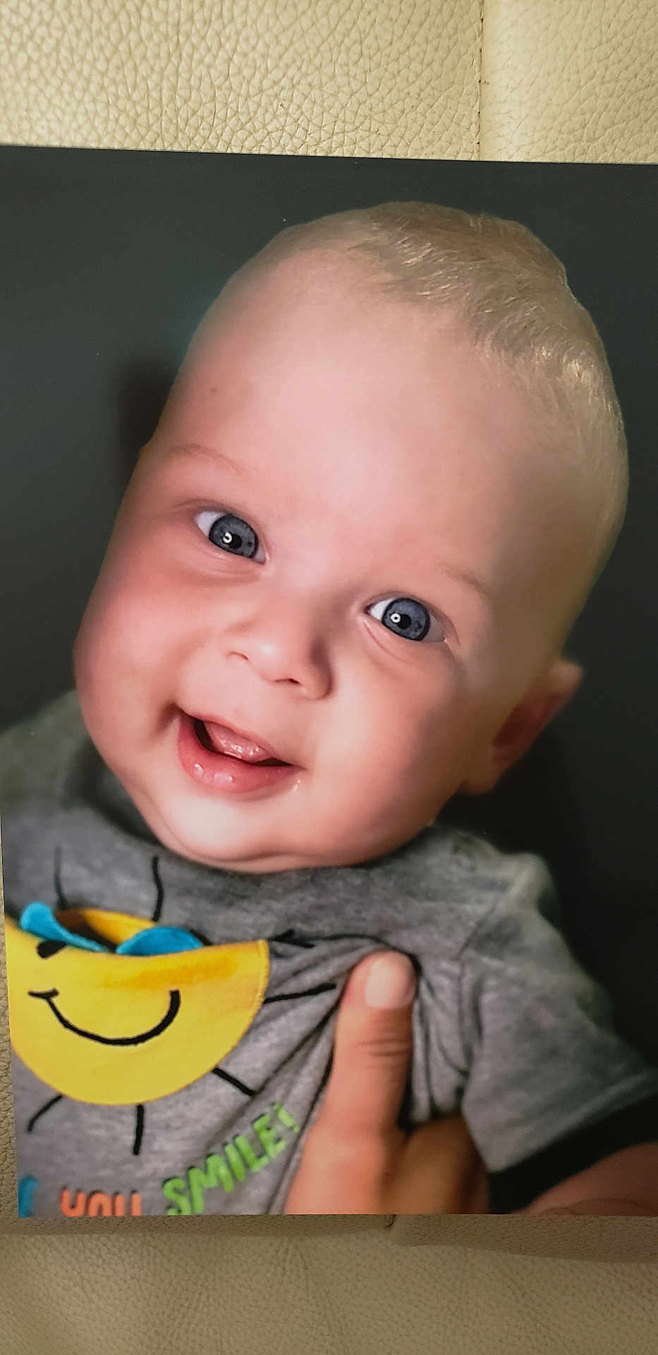 Milan joined the competition — help win amazing prizes! baby, smiling, blue_eyes, close_up, portrait, child, tshirt, sun_graphic, hand, happy, cute, infant, face, skin, expression, cheerful, young, person, clothing, indoors
