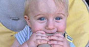 Eugène participe au concours pour gagner de l'argent avec cette photo : baby, blue_eyes, cardboard_tube, chewing, child, high_chair, yellow, striped_shirt, cute, hands, face, indoor, person, infant, furniture, seat, smiling, playful, closeup, portrait