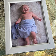 Maximo joined the competition — help win amazing prizes! baby, towel, white_frame, fluffy_rug, smile, infant, portrait, child, table, glass_table, texture, reflection, indoor, cute, skin, bare_chest, happy, lying_down, photograph, decor