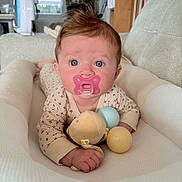 Alix a rejoint le concours — aidez-le/la à gagner de superbes lots ! baby, baby_girl, blanket, blue_eyes, child, clothing, comfort, cushion, cute, face, hand, home, indoor, infant, lying_down, pacifier, person, portrait, soft_toy, toy