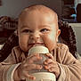 Milo participe au concours pour gagner de l'argent avec cette photo : baby, bottle, child, clothing, cozy, cute, face, feeding, hands, high_chair, indoor, infant, light, mischievous, person, portrait, sitting, smile, warm, young