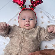 Mencia a rejoint le concours — aidez-le/la à gagner de superbes lots ! baby, infant, reindeer_ears, headband, knitwear, beige_clothing, star_pattern, blanket, hand, cute, portrait, indoors, holiday, festive, child, face, expression, cozy, soft, lying_down