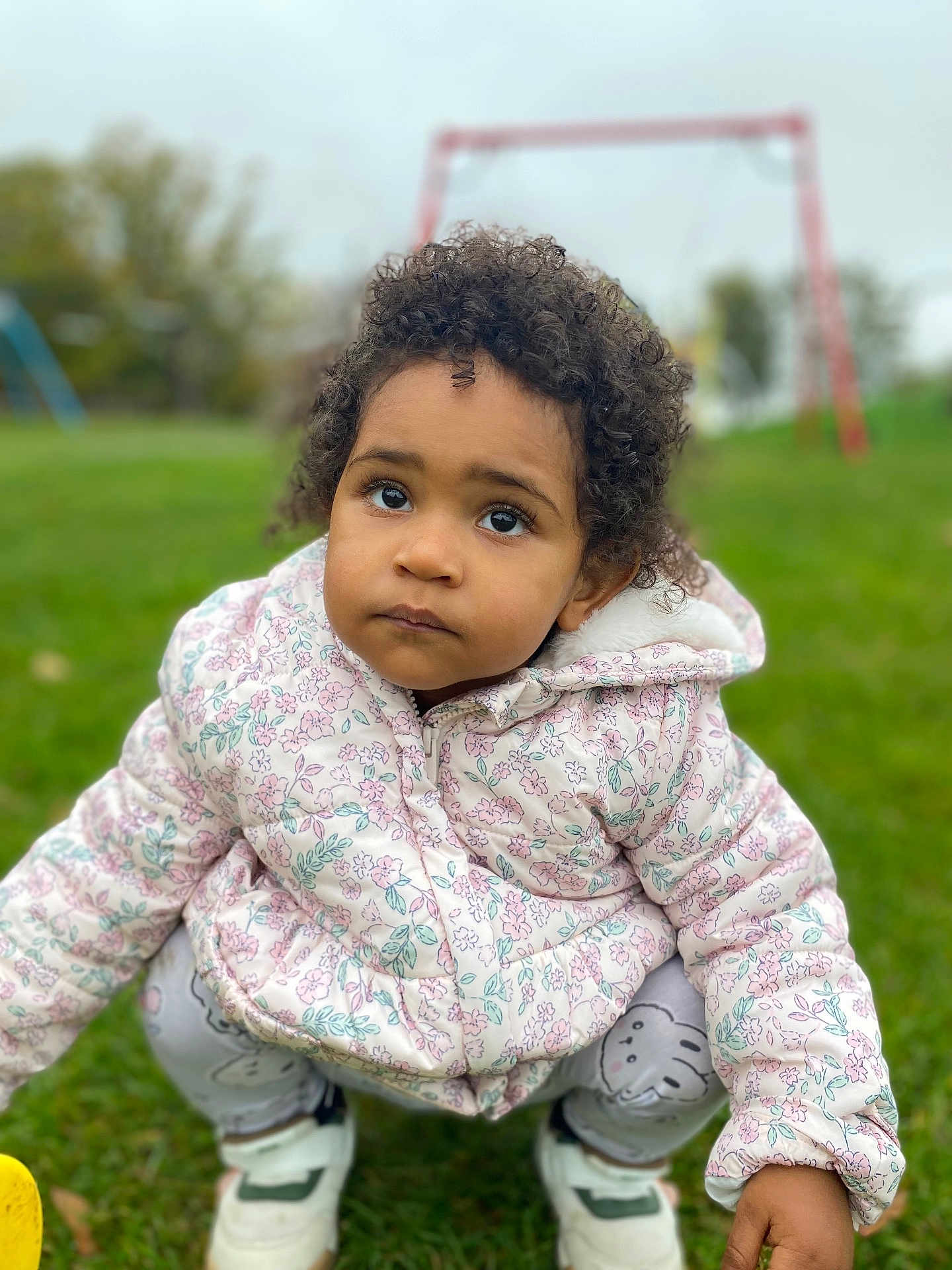 Josephine joined the competition — help win amazing prizes! toddler, child, grass, outdoor, jacket, curly_hair, sneakers, playground, swing, leggings, expression, candid, cute, nature, squatting, person, daylight, park, clothing, young