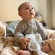 Ayden participe au concours pour gagner de l'argent avec cette photo : baby, bed, blanket, child, clothing, comfort, cozy, cute, expression, fabric, foot, hand, indoor, infant, neutral_colors, portrait, sitting, skin, soft_toy, warm_light