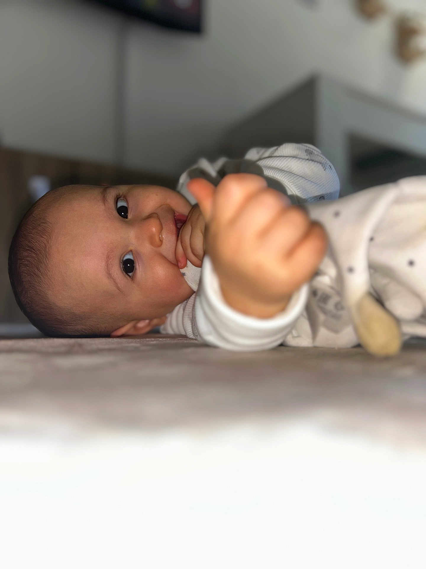 Ayden a rejoint le concours — aidez-le/la à gagner de superbes lots ! baby, blanket, blurred_background, chewing, child, clothing, cozy, cute, eyes, face, floor, hand, head, home, indoor, infant, person, smiling, soft_light, thumbs_up