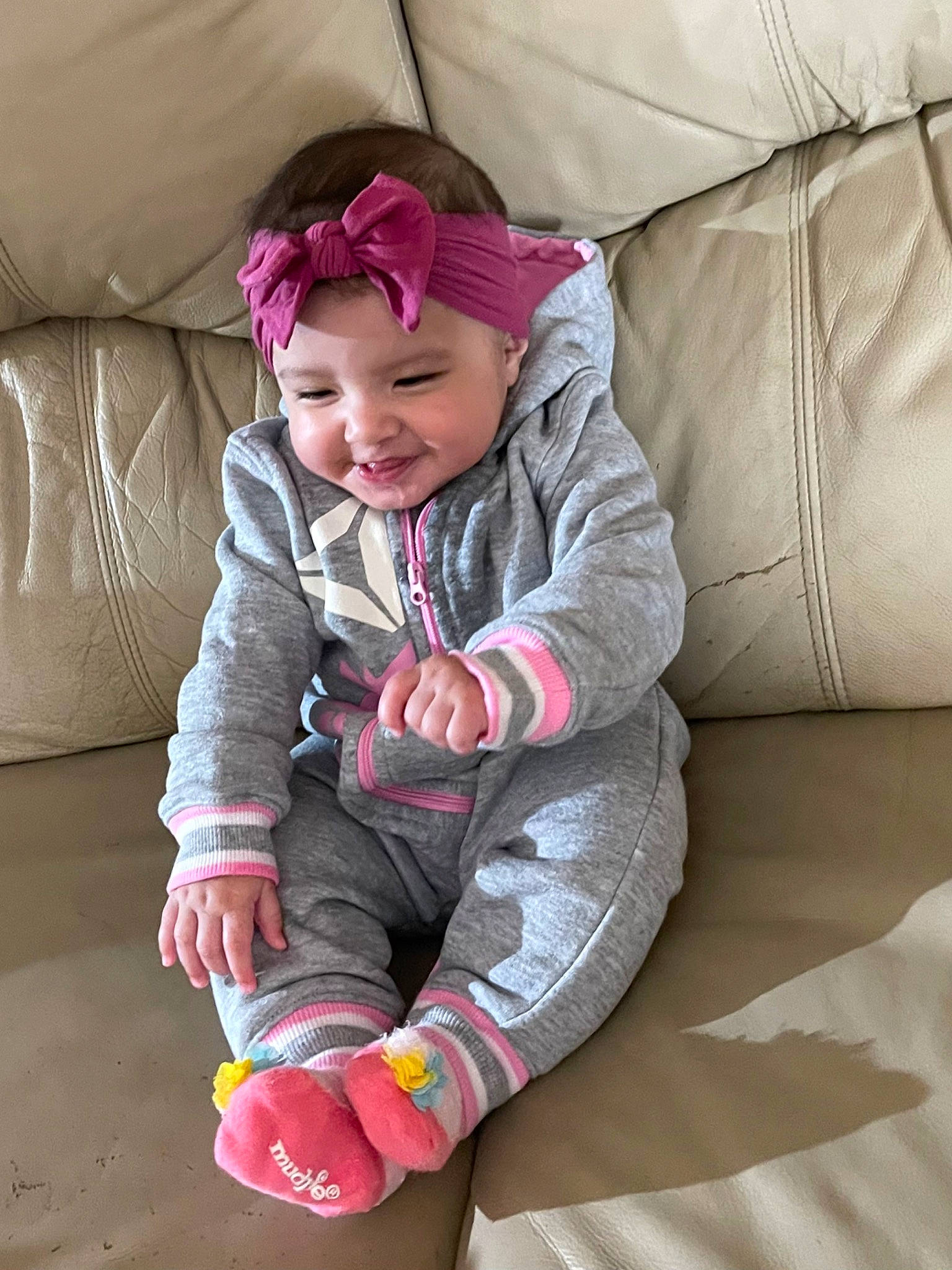 Ellie is registered to the contest to win money with this photo: baby, baby_toddler_clothing, cap, child, comfort, fun, grass, happy, headwear, jacket, joy, leisure, magenta, outerwear, person, play, sitting, skin, sleeve, smile