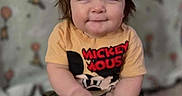 Maximilian is registered to the contest to win money with this photo: baby, balloons, barefoot, brown_hair, carpet, child, clothing, face, happy, home, indoor, mickey_mouse, photography, portrait, sitting, smiling, toddler, toy, wallpaper, yellow_ball