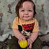 baby, child, toddler, sitting, smiling, happy, portrait, face, mickey_mouse, yellow_ball, toy, carpet, indoor, home, wallpaper, balloons, clothing, barefoot, brown_hair, photography
