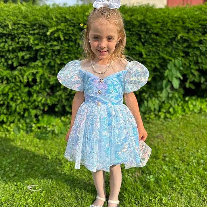 Evelyn is registered to the contest to win money with this photo: blue_dress, bow, child, dress, fashion, girl, grass, greenery, hair_bow, happy, hedge, outdoor, pearl_necklace, person, portrait, puffy_sleeves, shoes, smiling, sunlight, white_shoes
