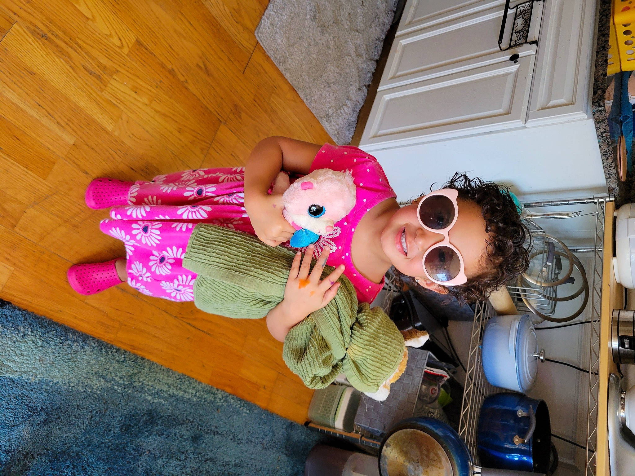 Emilia joined the competition — help win amazing prizes! baby_toddler_clothing, doll, eyewear, flooring, goggles, happy, hardwood, hat, joy, magenta, nail, person, pink, plush, smile, stuffed_toy, sunglasses, toy, vision_care, wood