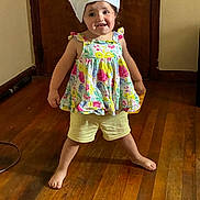Savannah joined the competition — help win amazing prizes! child, toddler, chef_hat, paper_hat, floral_dress, shorts, standing, smiling, indoors, wooden_floor, wooden_door, portrait, full_body, playful, costume, kitchen_theme, home, barefoot, happy, photography