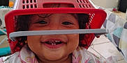 Alejandra is registered to the contest to win money with this photo: toddler, child, smiling, indoor, basket, red, playful, cute, face, curly_hair, clothing, butterfly_print, happy, teeth, pajamas, person, baby, fun, expression, home