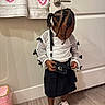 accessory, black_purse, black_skirt, braided_hair, casual, child, curious, cute, door, fashion, indoor, looking_down, person, pink_trash_bin, standing, towels, white_mesh_top, white_sneakers, wooden_floor, young_child