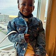 Zayda joined the competition — help win amazing prizes! accessory, child, curtain, cute, daylight, denim_jacket, dimple, face, fashion, happy, indoor, pants, person, portrait, purse, screen, seated, smile, urban, window