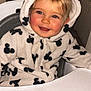 toddler, child, smiling, face, hoodie, onesie, mickey_mouse_pattern, high_chair, indoor, blond_hair, baby, cute, happy, childrens_clothing, person, portrait, seated, infant, red_eye, zipper