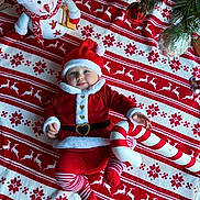 Victoria a rejoint le concours — aidez-le/la à gagner de superbes lots ! baby, candy_cane, child, christmas, costume, cute, festive_blanket, happy, holiday, holiday_decor, indoor, pine_branches, plush_snowman, portrait, red_and_white, santa_claus_costume, seasonal, smiling, striped_tights, toy