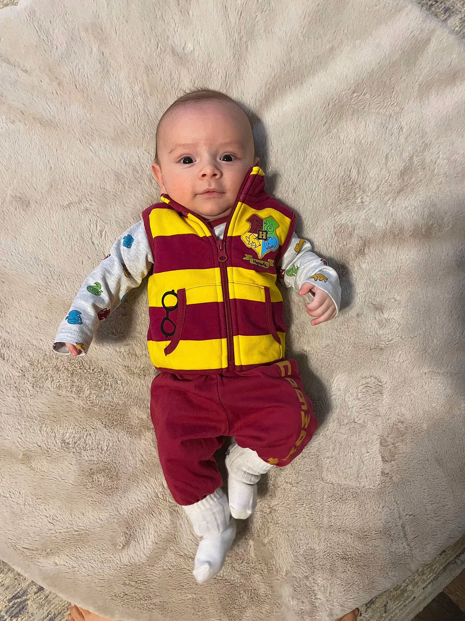 Marcus is registered to the contest to win money with this photo: art, baby, baby_products, baby_toddler_clothing, child, eye, flooring, happy, head, jacket, linens, orange, outerwear, pattern, person, sleeve, smile, t_shirt, textile, toddler