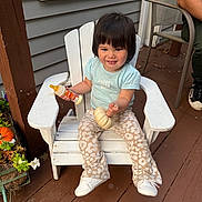 Alina is registered to the contest to win money with this photo: toddler, child, white_chair, pumpkin, baby_bottle, porch, wooden_floor, flower_pot, plants, person, casual_clothing, smiling, short_hair, sitting, outdoor, fall_decor, footwear, light_blue_shirt, patterned_pants, happy