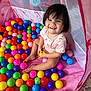 Alina joined the competition — help win amazing prizes! toddler, child, play_tent, plastic_balls, colorful, smiling, happy, indoor, toy, playtime, pink, purple, yellow, green, blue, red, orange, person, short_hair, casual_clothing
