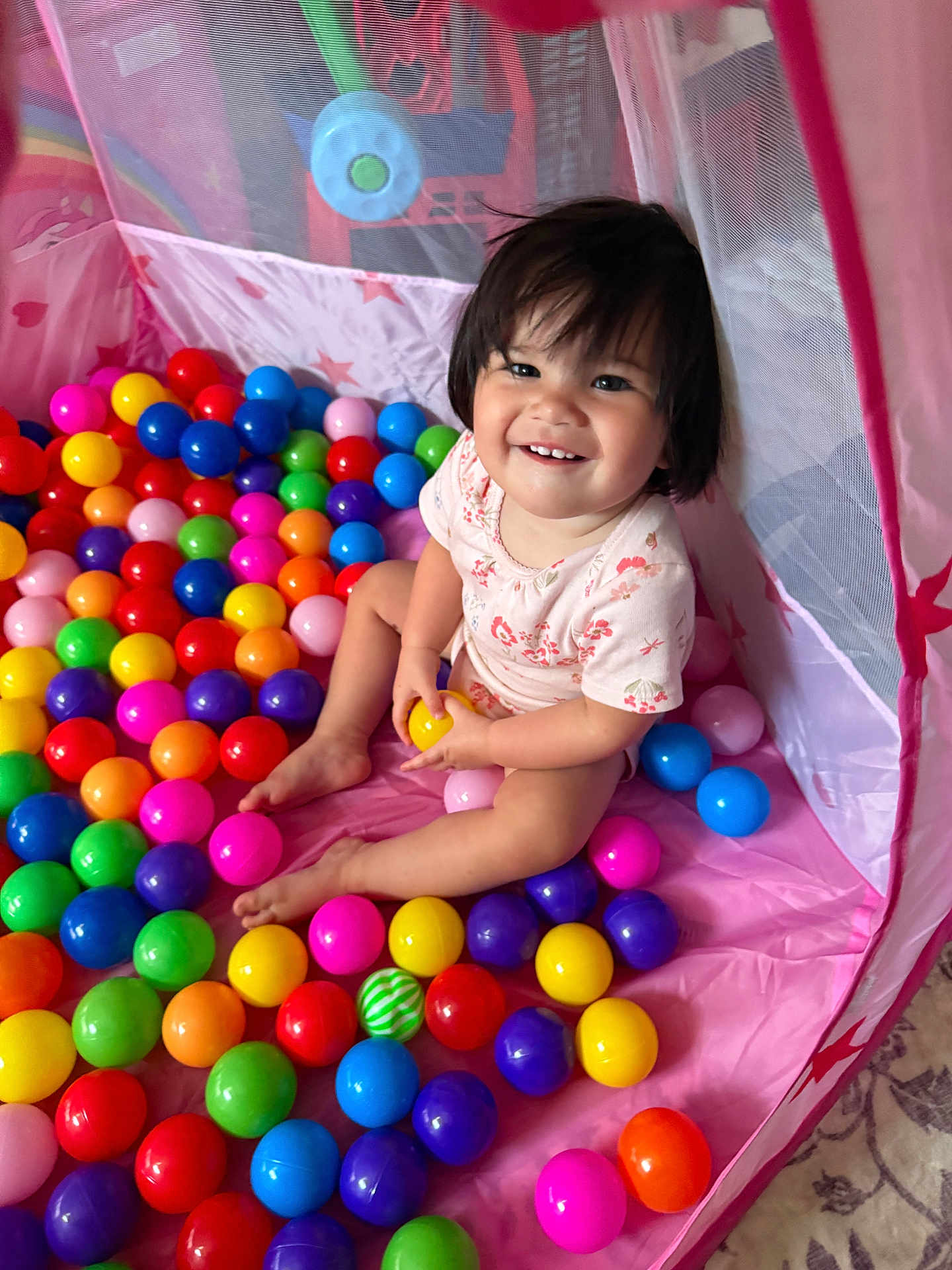 Alina joined the competition — help win amazing prizes! toddler, child, play_tent, plastic_balls, colorful, smiling, happy, indoor, toy, playtime, pink, purple, yellow, green, blue, red, orange, person, short_hair, casual_clothing
