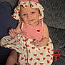 Ava joined the competition — help win amazing prizes! baby, infant, child, couch, watermelon_pattern, hat, dress, smile, indoors, pacifier, clothing, person, cute, sitting, fabric, texture, hand, foot, portrait, relaxation