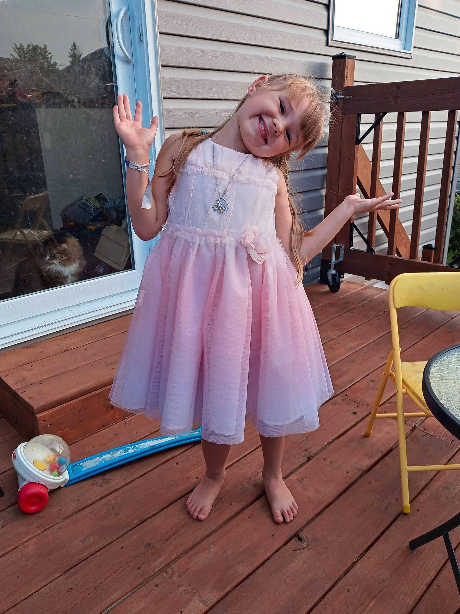 Ophélia a rejoint le concours — aidez-le/la à gagner de superbes lots ! baby_toddler_clothing, barefoot, blond, chair, dress, floor, flooring, foot, happy, hardwood, human_leg, joy, leisure, outdoor_furniture, pattern, person, pink, smile, summer, toddler