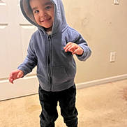 Karson joined the competition — help win amazing prizes! toddler, child, hoodie, blue_clothing, indoor, carpet, door, smile, happy, standing, person, young_child, casual_clothing, pants, white_shoes, wall, light_switch, playful, cute, portrait