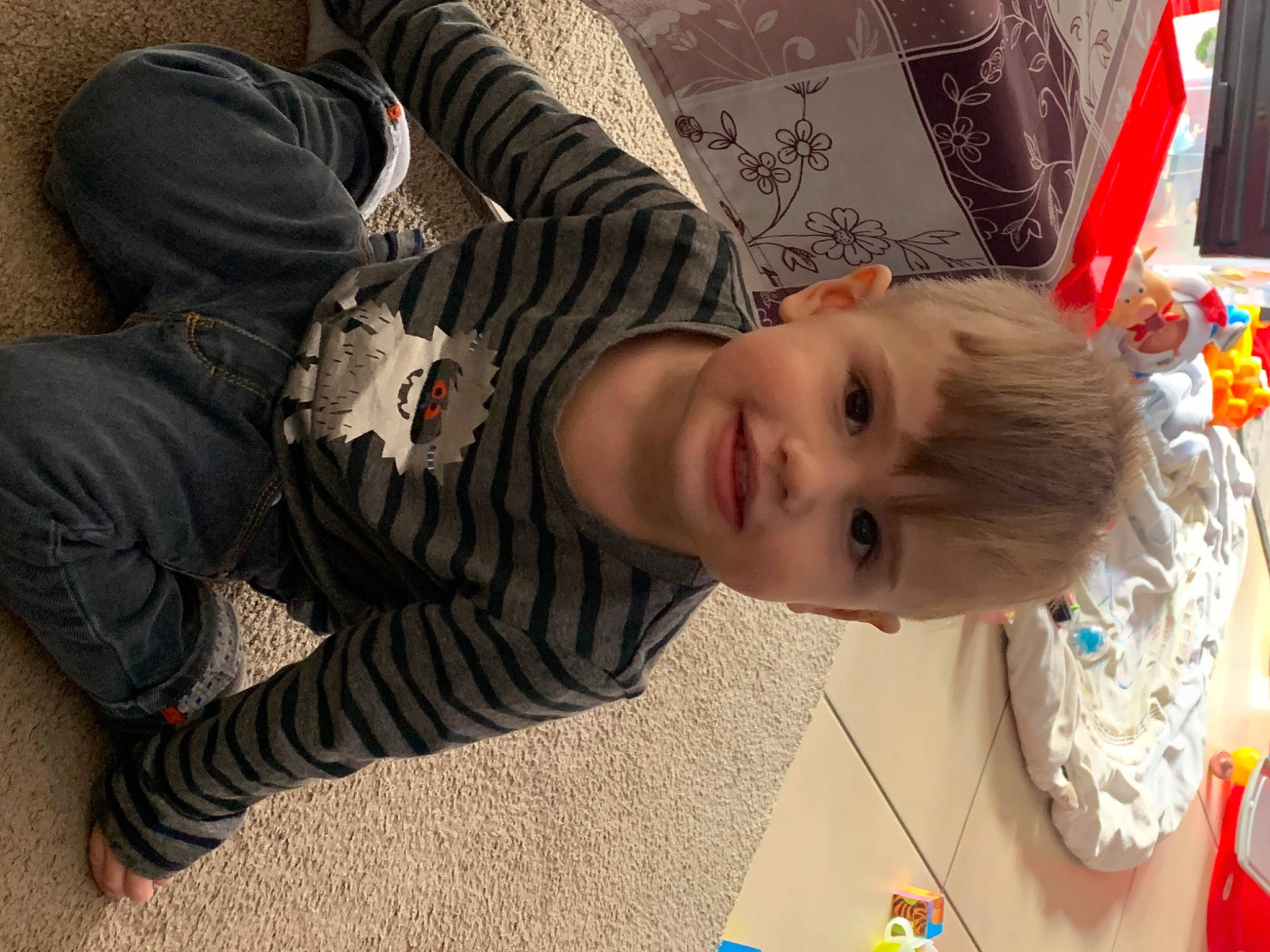 Nëlyo a rejoint le concours — aidez-le/la à gagner de superbes lots ! baby, cheek, child, comfort, face, facial_expression, flooring, fun, happy, joy, person, room, sitting, smile, toddler, tree, wood