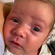 Waylen is registered to the contest to win money with this photo: baby, close_up, face, infant, newborn, eyes, skin, clothing, patterned_background, curious, soft_skin, cute, child, portrait, young, indoors, snuggle, cozy, expression, head