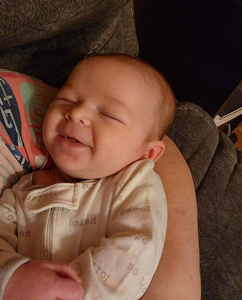 Braxton is registered to the contest to win money with this photo: arm, baby_toddler_clothing, cheek, chin, comfort, ear, eye, eyebrow, face, hand, head, human_body, lip, mouth, neck, nose, person, skin, sleeve, smile