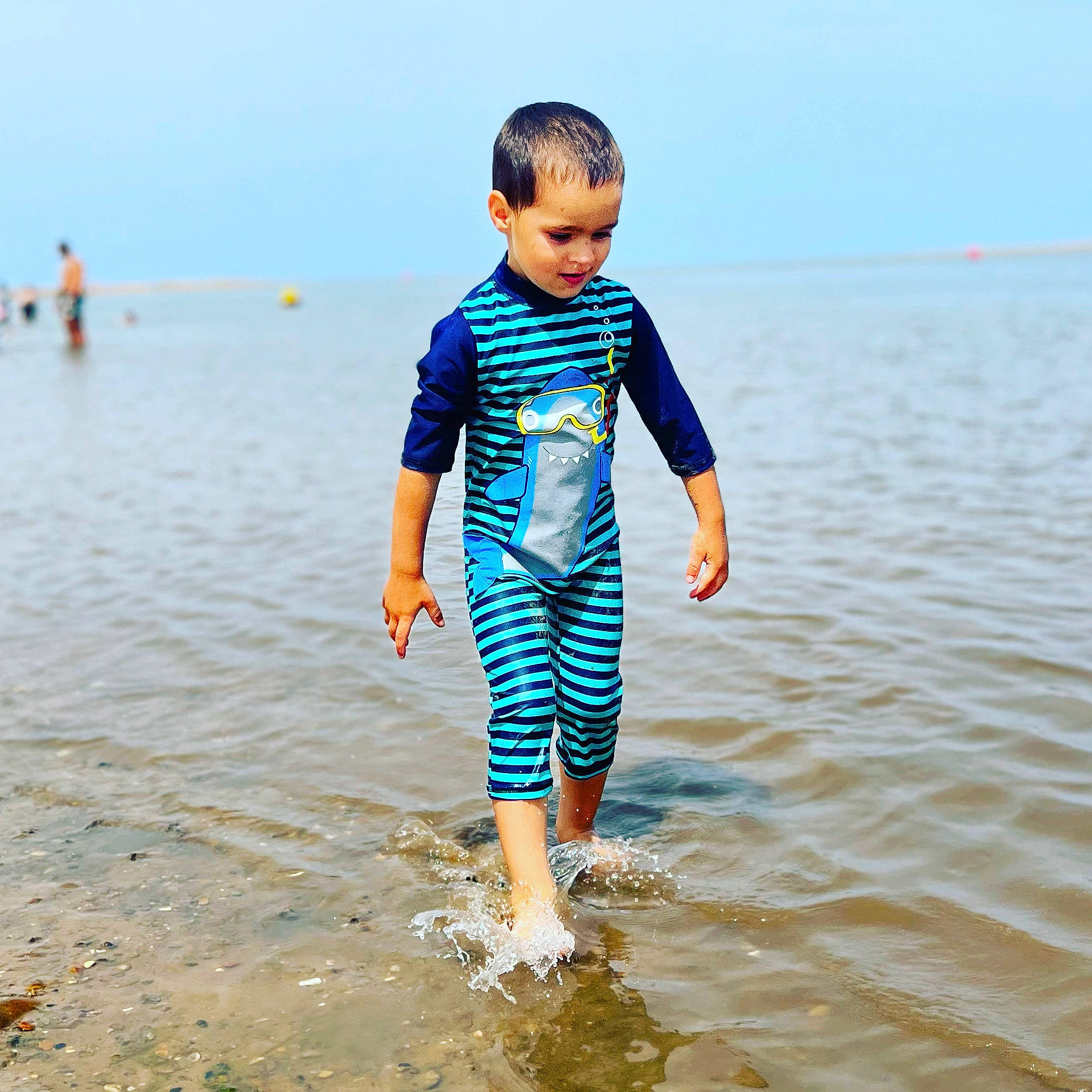 Lucas joined the competition — help win amazing prizes! azure, beach, body_of_water, coastal_and_oceanic_landforms, electric_blue, fun, gesture, happy, horizon, leisure, people_in_nature, people_on_beach, person, shirt, sky, sleeve, summer, t_shirt, toddler, water